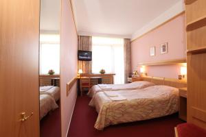 Postel nebo postele na pokoji v ubytování Hotel Akademie a depandance Vila Jarmila