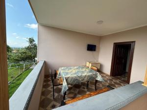 a room with a table and a balcony with a view at Irakli Guest House in Tsqaltubo