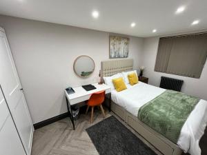 a bedroom with a bed and a desk and a mirror at Fabulous 3 Bed Apartment - Near Excel - Sleeps 6 - 8 in London +4 photos