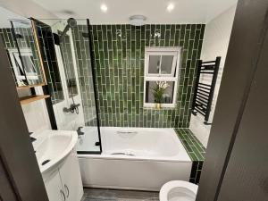 a bathroom with a tub and a toilet and a sink at Fabulous 3 Bed Apartment - Near Excel - Sleeps 6 - 8 in London