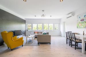 ブダペストにあるEarthy Elegance Apartmentのリビングルーム(黄色い椅子、ソファ付)