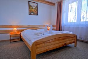 a bedroom with a wooden bed and a window at Ośrodek Wczasowy Groń Placówka in Białka Tatrzańska