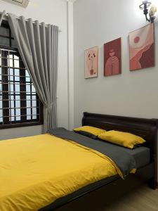 a bedroom with a bed with yellow sheets and a window at Susu Homestay Hue in Thôn Kim Long (1)