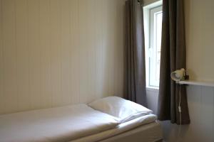 a small bed in a room with a window at Orkla Camping in Orkanger