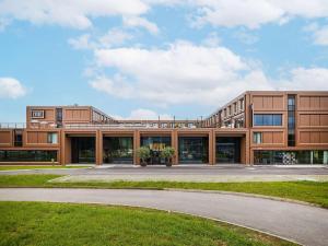 an office building with a road in front of it at TRIBE Milano Malpensa in Vizzola Ticino