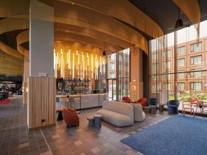 a lobby with a white couch and chairs in a building at TRIBE Milano Malpensa in Vizzola Ticino