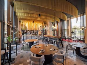 a restaurant with tables and chairs and a bar at TRIBE Milano Malpensa in Vizzola Ticino