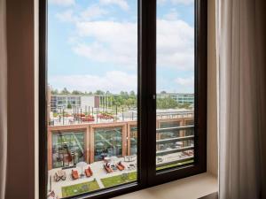 a window with a view of a city at TRIBE Milano Malpensa in Vizzola Ticino