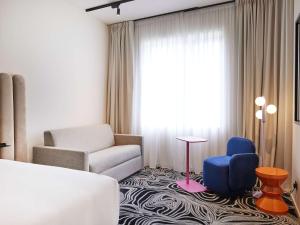 a living room with a couch and a chair at TRIBE Milano Malpensa in Vizzola Ticino