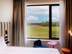 a hotel room with a bed and a window at TRIBE Milano Malpensa in Vizzola Ticino