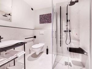 a white bathroom with a shower and a toilet at TRIBE Milano Malpensa in Vizzola Ticino