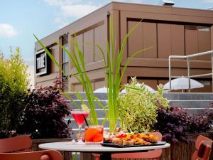 a table with a plate of food and a glass of wine at TRIBE Milano Malpensa in Vizzola Ticino