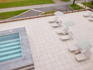 an overhead view of a patio with chairs and a pool at TRIBE Milano Malpensa in Vizzola Ticino
