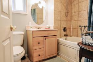 a bathroom with a toilet and a sink and a tub at Charming Lake Huron Cottage Private Beach Access in Oscoda +21 photos
