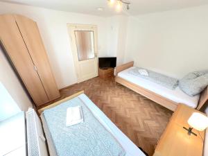 une petite chambre avec deux lits et une table dans l'établissement II Apartment 6 Personen - Monteurzimmer - Ferienwohnung - Großköllnbach, à Pilsting 2 autres photos