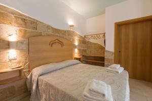 a bedroom with a bed and a stone wall at Tenuta Solentino in Ugento
