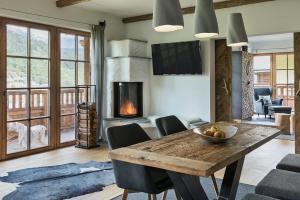 a living room with a wooden table and a fireplace at Das Chalet in Schladming
