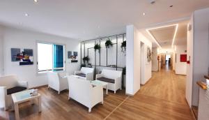 a living room with white chairs and a table at Villa Serena in Lido di Jesolo