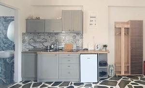 a kitchen with white cabinets and a white refrigerator at Dendrinos studio in Galissas