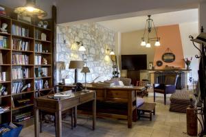 - un salon avec un bureau et un mur en pierre dans l'établissement Villa Pepy, à Áyios Konstandínos