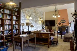a living room with a desk and a stone wall at Villa Pepy in Áyios Konstandínos