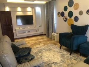 een woonkamer met een bank en een flatscreen-tv bij Bridges incorporated limited in Entebbe