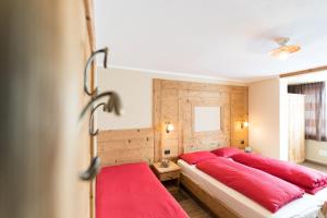 a bedroom with red pillows on a bed at Hotel Champagne in Livigno