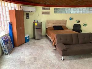 a bedroom with a bed and a couch at Bungalow Kbo in Cabo San Lucas