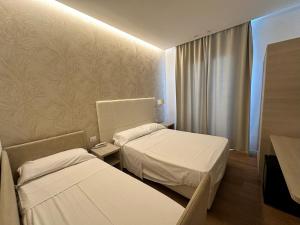a hospital room with two beds and a window at Hb Hotels Orchidea Blu in Rimini