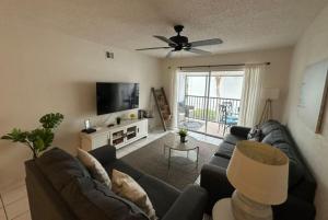 a living room with a couch and a flat screen tv at Siesta Key White Sands Condo in Siesta Key