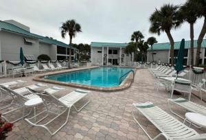 a swimming pool with chairs and a bunch ofitures at Siesta Key White Sands Condo in Siesta Key