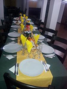 a long table with plates and wine glasses on it at Pensiunea Elena in Vistisoara