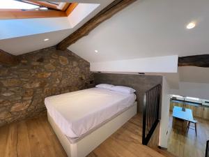 a bedroom with a bed and a stone wall at Apartamento completo ideal para estancias y trabajo - Ferrol by Miramar Stays in Ferrol