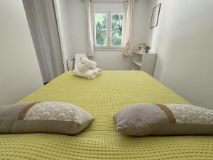 - une chambre avec un grand lit jaune et 2 oreillers dans l'établissement L'Auguière Est, maisonnette sans vis-à-vis et au calme avec vue sur les vignes, à Hyères 2 autres photos