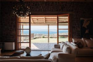 a living room with a couch and a large window at Terra Casa Private Villa in Aegina Island in Vathí