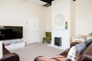 a living room with a couch and a television at Above The Pub in Alvechurch