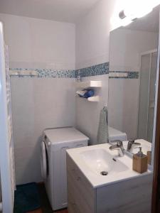 a white bathroom with a sink and a toilet at Appartement chalet en plein centre des Saisies in Hauteluce