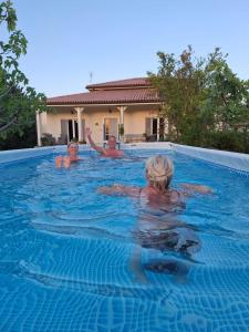 three children are swimming in a swimming pool at Villa Vista Monti in Bolognano