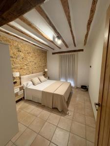 a bedroom with a bed and a stone wall at Casas rurales de La Fuente in Villora +5 photos