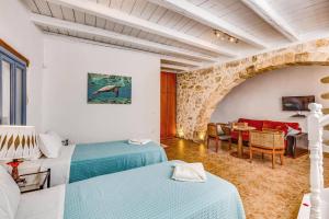 a bedroom with two beds and a living room at Villa Epavlis by Villa Plus in Plaka +20 photos