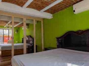 a bedroom with green walls and a bed at Casa Cabo, Bungalow & Surf in Cabo San Lucas