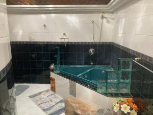 a bathroom with a green tub on a tiled wall at Casa Cabo, Bungalow & Surf in Cabo San Lucas +31 photos