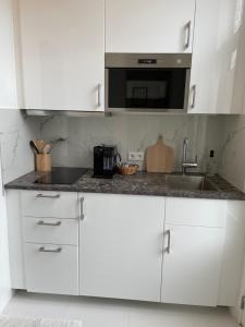 a white kitchen with a sink and a microwave at Bed and Breakfast Always Good in Utrecht