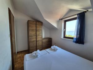 a bedroom with a white bed and a window at Villa Ela in Postira