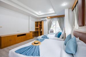 a bedroom with two beds and a large window at About A Beach Pool Villa Bangsaray in Bang Sare +41 photos