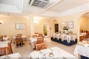 a dining room with white tables and chairs at Hotel Tenerife in Riccione