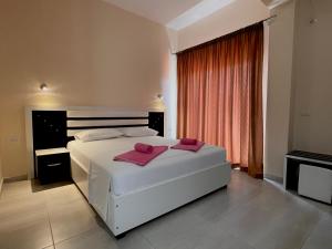 a bedroom with a white bed with pink towels on it at Marku Palace in Ksamil +37 photos