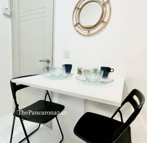 a white table with a black chair and a mirror at The Pancarona240 in Seri Iskandar