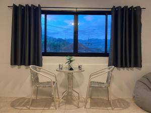 a table and two chairs in front of a window at 84 Bar & Guest House in Ban Huai Luk (1)