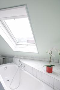 un lucernario in bagno con vasca e finestra di Hotel Kellhof - Bed & Breakfast a Gaienhofen Altre 26 foto